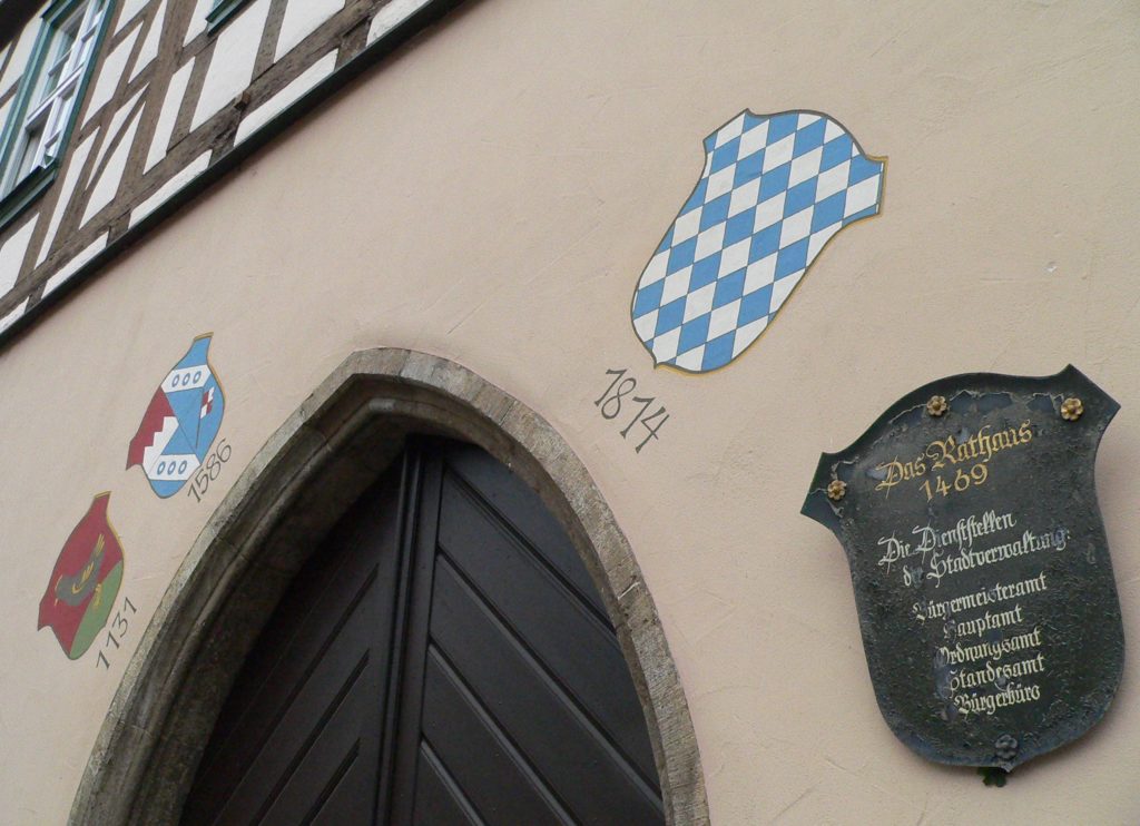 Am historischen Rathaus ist abzulesen, dass auf die Herrschaft der Grafen von Henneberg die der Würzburger Fürstbischöfe folgte.