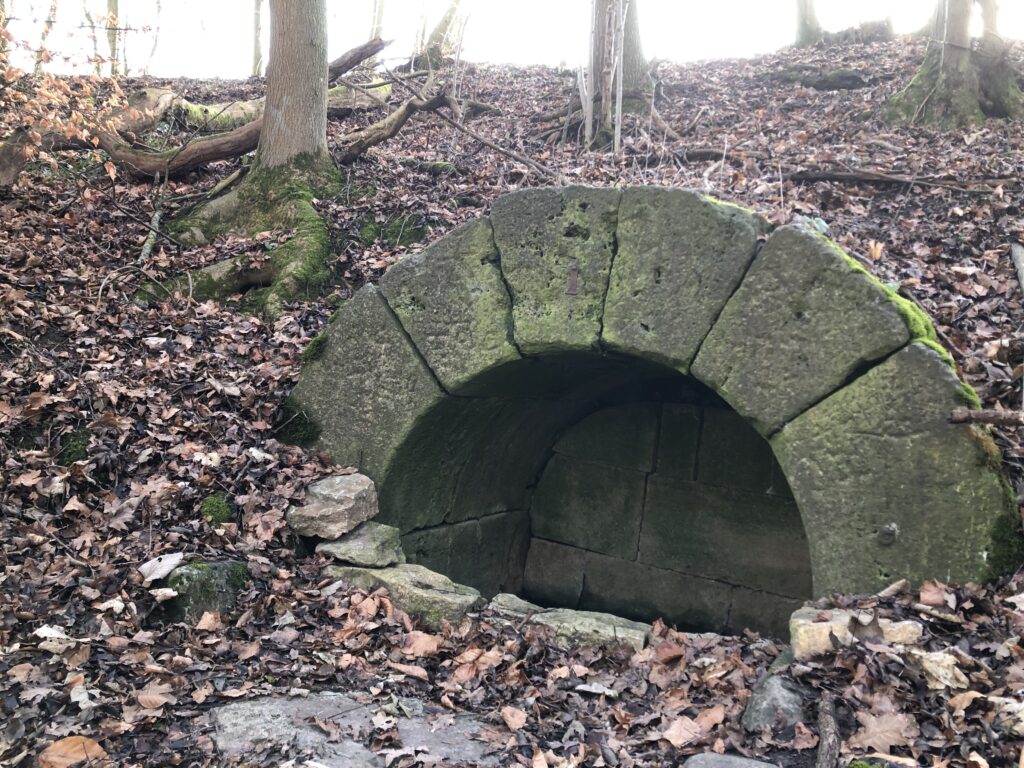 Aus Sandstein mit einem Rundbogen gemauerte Brunnenstube der Lützelquelle.
